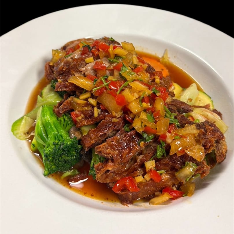 Crispy duck with pineapple, bell peppers, and broccoli in a savory sauce from Kenzo Thai & Sushi.