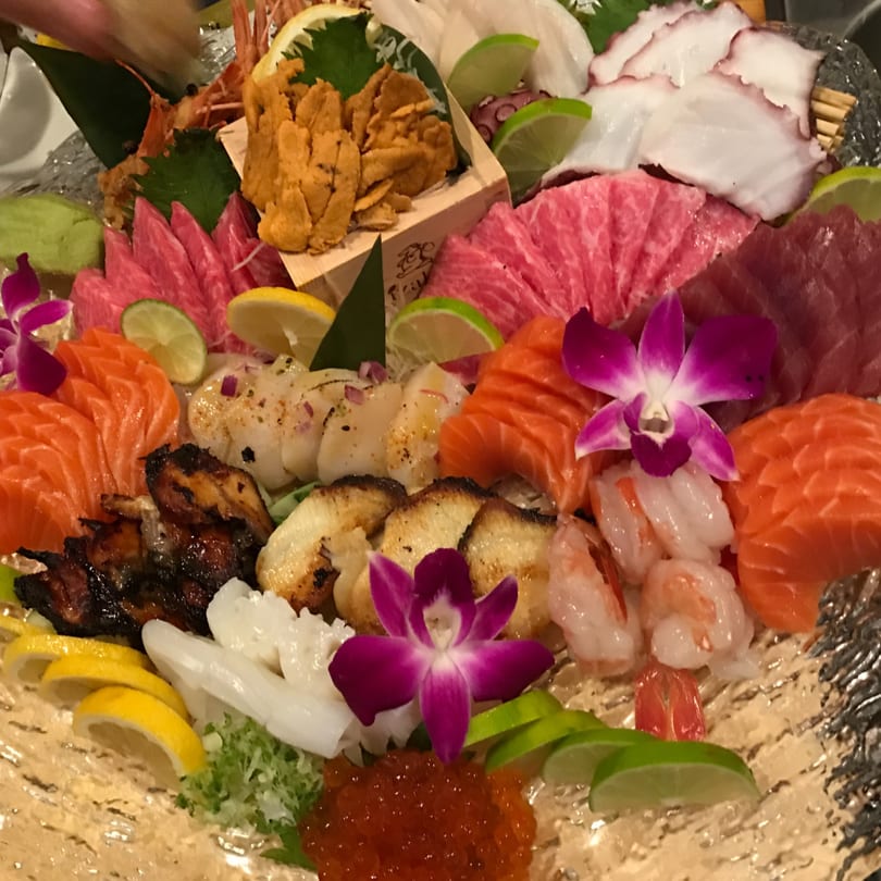 A large platter of Kenzo Thai & Sushi's fresh sashimi, including salmon, tuna, scallops, and octopus.