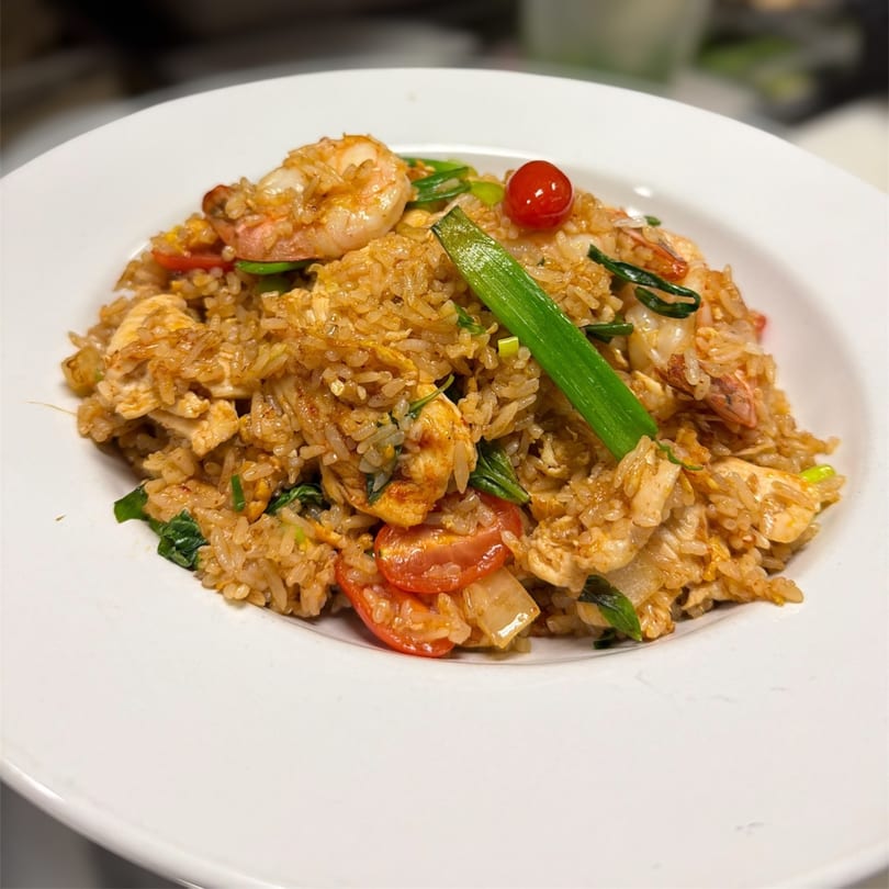 A close-up of Kenzo Thai & Sushi's fried rice with shrimp, chicken, tomatoes, and green onions.
