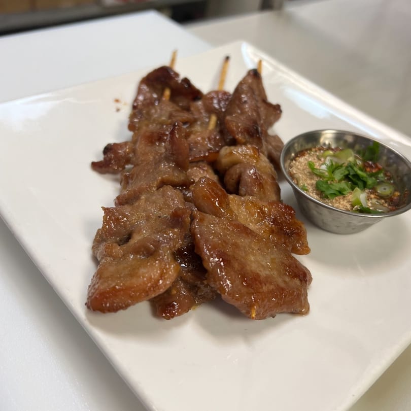 Kenzo Thai & Sushi's grilled pork skewers with a side of spicy dipping sauce.